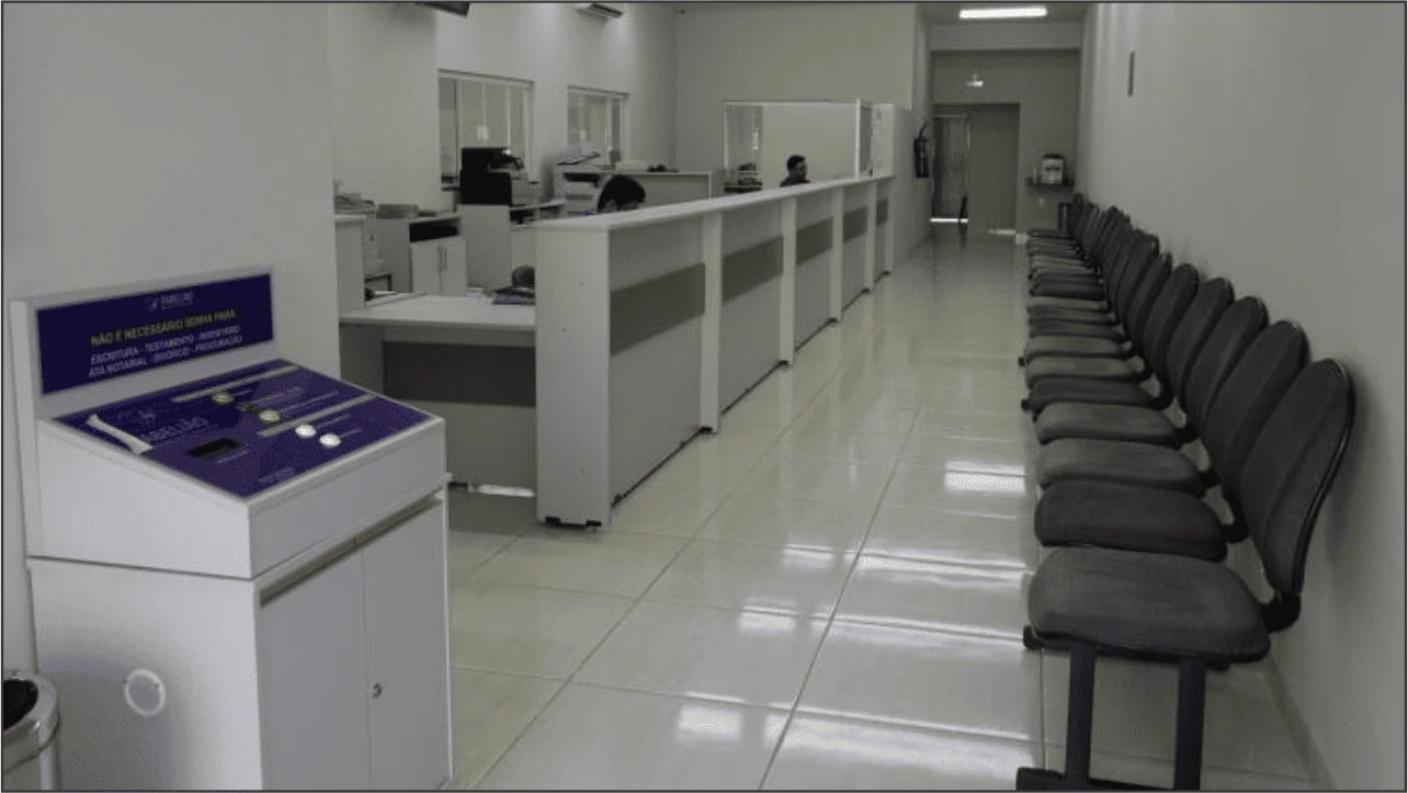 Interior de cartório com móvel de geração de senhas à esquerda